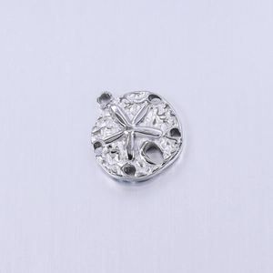 Macro shot of silver starfish pendant with hollow details and organic textures