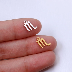 Macro view of gold and silver Scorpio constellation charms for DIY necklace making