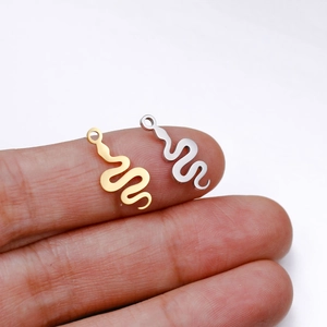 Close-up of small flat snake charms in gold and silver finish for DIY jewelry crafting