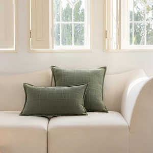Detail of moss green jacquard checkered cushion covers with elegant ruffled edges