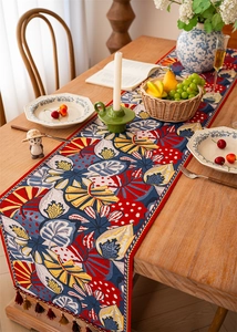 Close-up of jacquard table runner with tropical leaf patterns and elegant fringe tassels