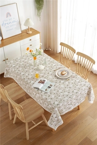 Detailed close-up of white dandelion lace trim on a floral cotton linen tablecloth