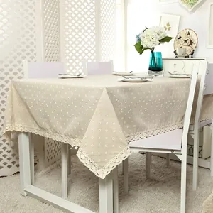 Close-up of beige tablecloth featuring daisy prints and elegant wide lace trim edges