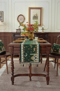 Detail of dark green Ramadan table runner featuring mosque motifs and golden tassels