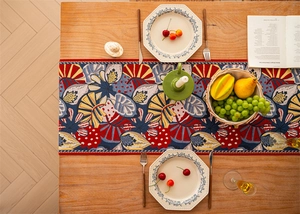 Top-down view of tropical leaf pattern table runner on a wooden dining table