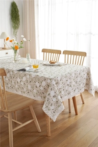 Close-up of white dandelion floral print on cotton linen tablecloth with lace edge