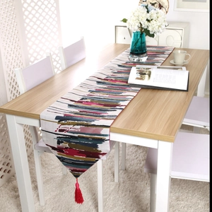 Detailed texture of colorful oil painting style table runner with vibrant red tassels
