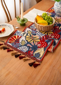 Close-up of ethnic jacquard table runner featuring tropical patterns and colorful tassels