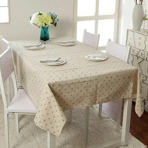 Detail of beige rectangular daisy tablecloth with small floral patterns on a table
