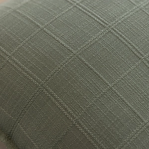 Macro view of sage green polyester pillowcase with waffle weave jacquard texture