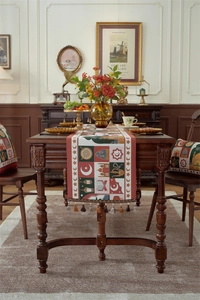 Close-up of woven jacquard table runner with moon patterns and colorful tassels