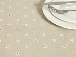 Detailed macro view of beige linen fabric with white daisy prints and lace trim
