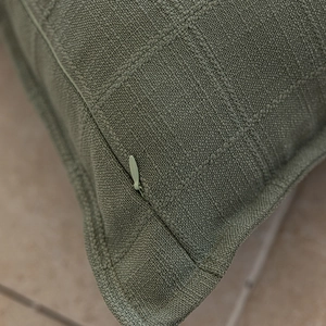 Detail view of grass green cushion cover showing woven grid texture and hidden zipper