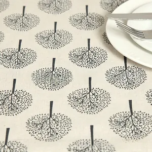 Detailed texture of cotton linen tablecloth featuring a minimalist black tree print pattern