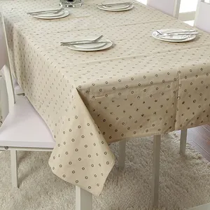 Close-up of beige linen tablecloth with black snowflake print and lace edge detail
