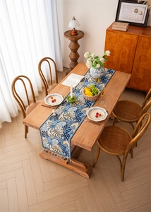Detail of tropical leaf jacquard pattern and handmade tassels on a blue table runner