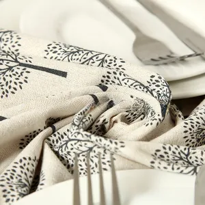 Close-up of modern apple tree pattern tablecloth with natural linen texture and cutlery