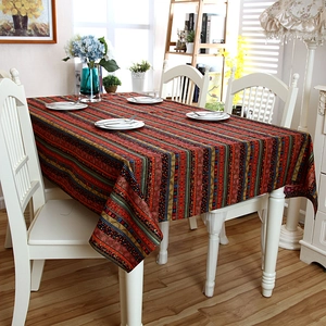 Detail of bohemian gold-striped linen tablecloth with intricate lace edges in home setting