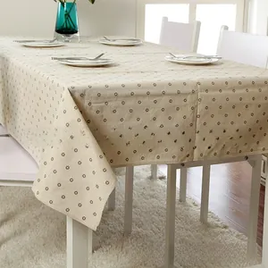 Detailed close-up of beige linen tablecloth with dark brown daisy floral print pattern