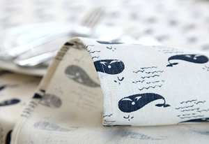 Macro shot showing whale prints and lace trim detail on the modern linen tablecloth