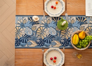Macro detail of tropical rainforest jacquard table runner with leaf pattern and tassels