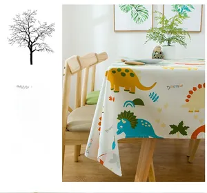 Close-up of cotton tablecloth with colorful dinosaur patterns on a wooden table