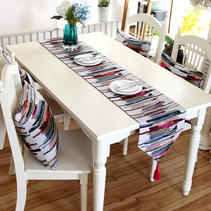 Detail of colorful abstract oil painting table runner with pink tassels and matching cushion