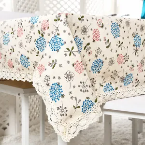 Close-up of white crochet lace trim on floral cotton linen tablecloth with dandelion prints