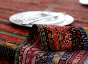 Detail of bohemian cotton linen tablecloth with gold stripes and intricate lace trim texture