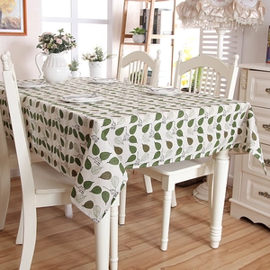 Detail of green leaf print tablecloth with rustic decorative text in a cozy home setting