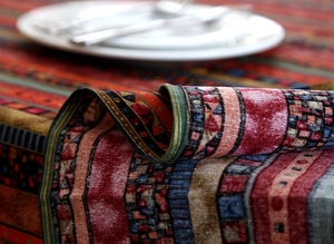 Detailed close-up showing the rich woven texture and ethnic geometric patterns on linen tablecloth