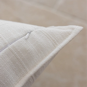 Detail shot of invisible zipper and textured linen fabric on beige cushion cover