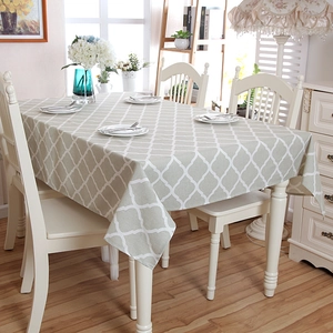 Detailed close-up of grey geometric lattice pattern cotton-blend tablecloth on dining table