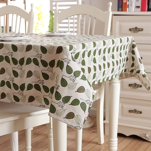 Detail of cotton polyester tablecloth featuring green leaf patterns and fabric texture