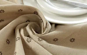 Detailed macro view of beige linen-cotton fabric with dark brown daisy floral print