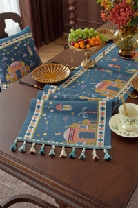 Detail of blue jacquard table runner with moon stars patterns and fringe tassels