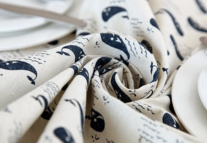 Close-up of minimalist whale print on textured cotton linen tablecloth fabric