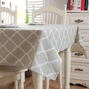 Close-up of modern gray-green tablecloth featuring white Moroccan trellis pattern
