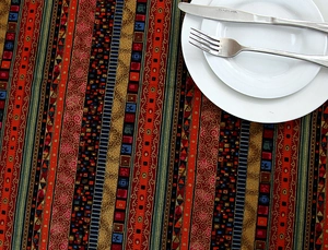 Detail of bohemian striped tablecloth with intricate patterns and lace borders