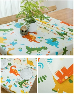 Close-up of thick cotton tablecloth featuring cartoon dinosaurs and neat overlock stitching