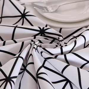 Detail of heavy cotton canvas tablecloth with black geometric pattern and dining setup