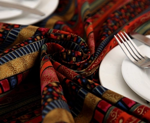 Close-up of bohemian linen tablecloth featuring gold stripes and intricate lace details
