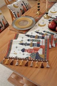 Close-up of jacquard table runner with mosque motifs, tassels and matching cushions
