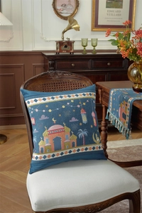Detail of blue Middle Eastern pillow with mosque embroidery on a vintage wooden chair