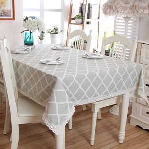 Detail of grey geometric tablecloth with cotton texture and delicate white lace edges