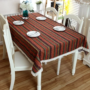 Close-up of bohemian striped tablecloth with intricate white lace border detail