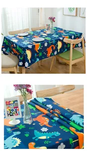 Close-up of thick cotton tablecloth featuring colorful cartoon dinosaur patterns on navy