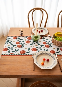 Detail of tropical rainforest pattern table runner with vibrant red tomato floral motifs