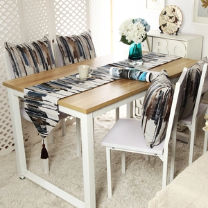 Detailed view of blue and brown striped table runner with matching cushions on a dining table