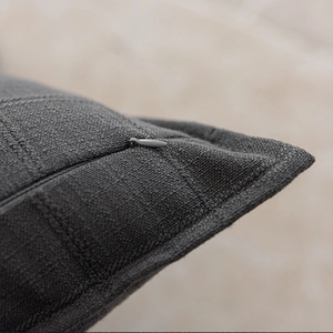Detailed macro view of the invisible zipper design on a dark gray textured cushion cover